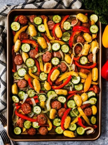 A sheet pan meal with smoked sausage, zucchini, bell peppers, onions, and gnocchi.