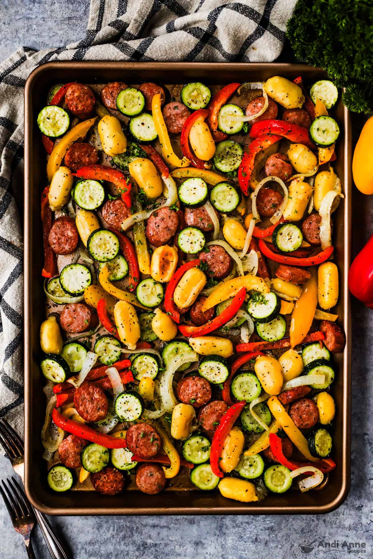 A sheet pan meal with smoked sausage, zucchini, bell peppers, onions, and gnocchi.