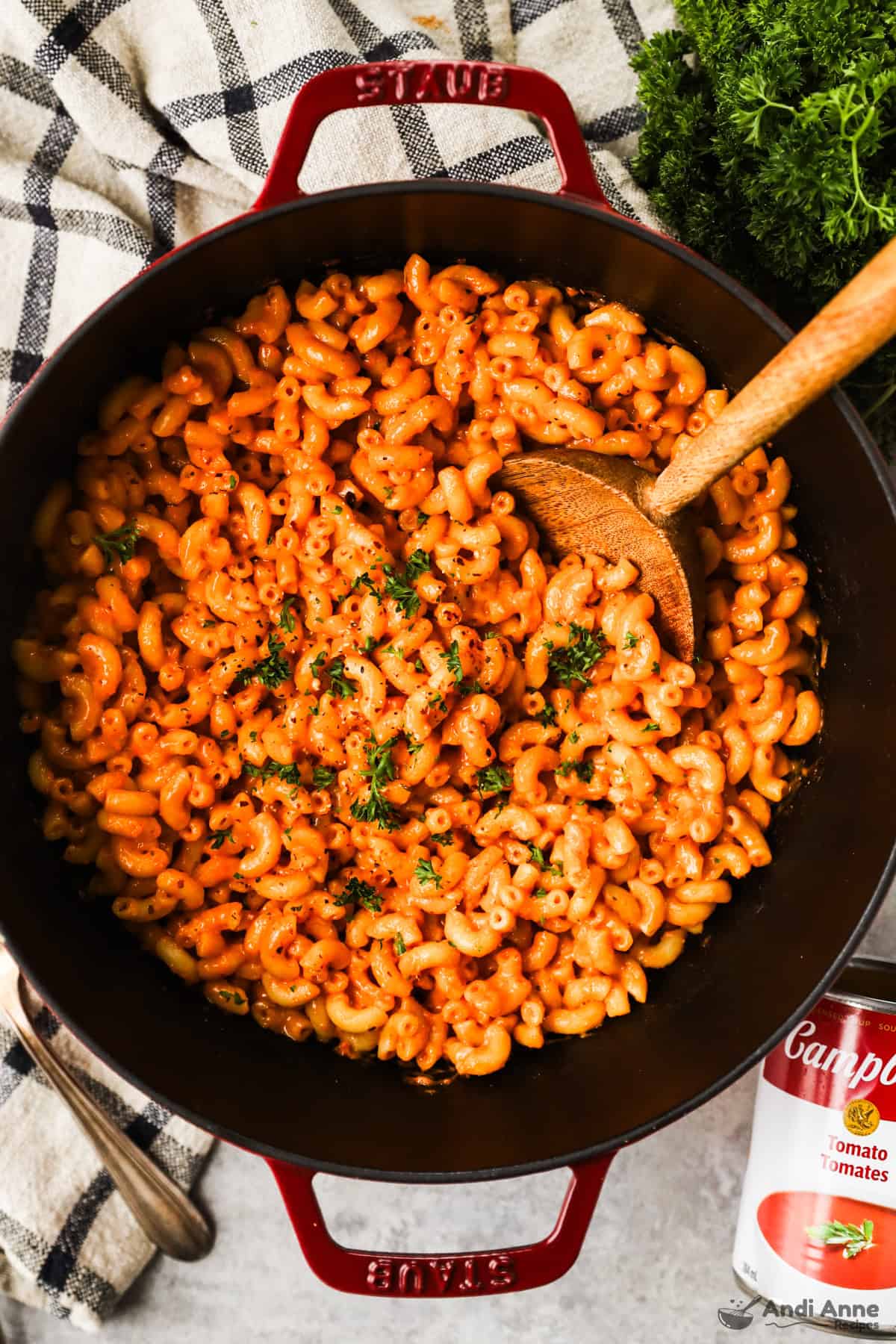 Tomato soup mac and cheese in a large pot with a wooden spoon.