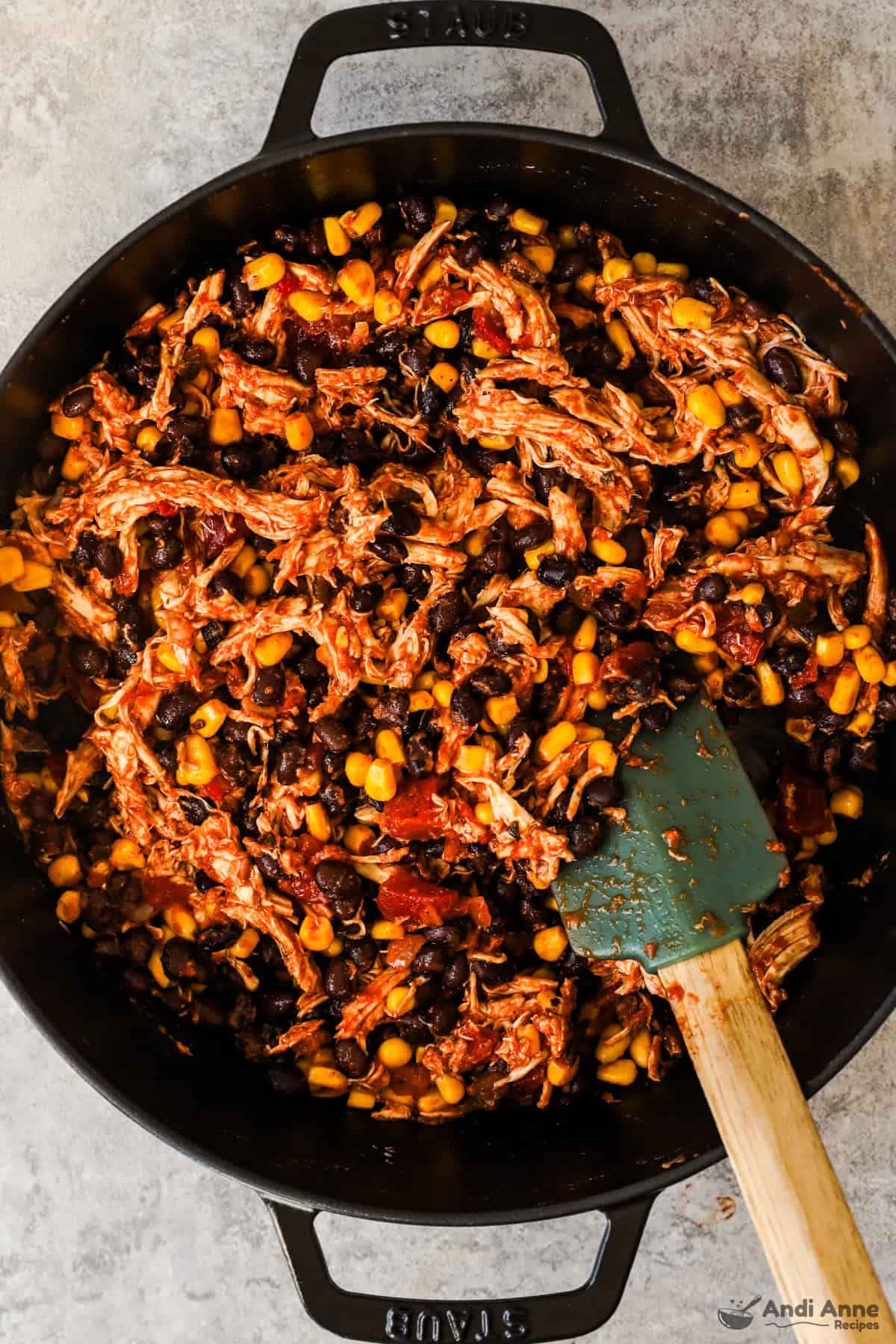 Rotisserie chicken, beans, and corn are mixed in a skillet with taco seasoning.