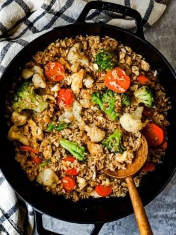 Egg fried rice with leftover broccoli, cauliflower, and carrots in a skillet.