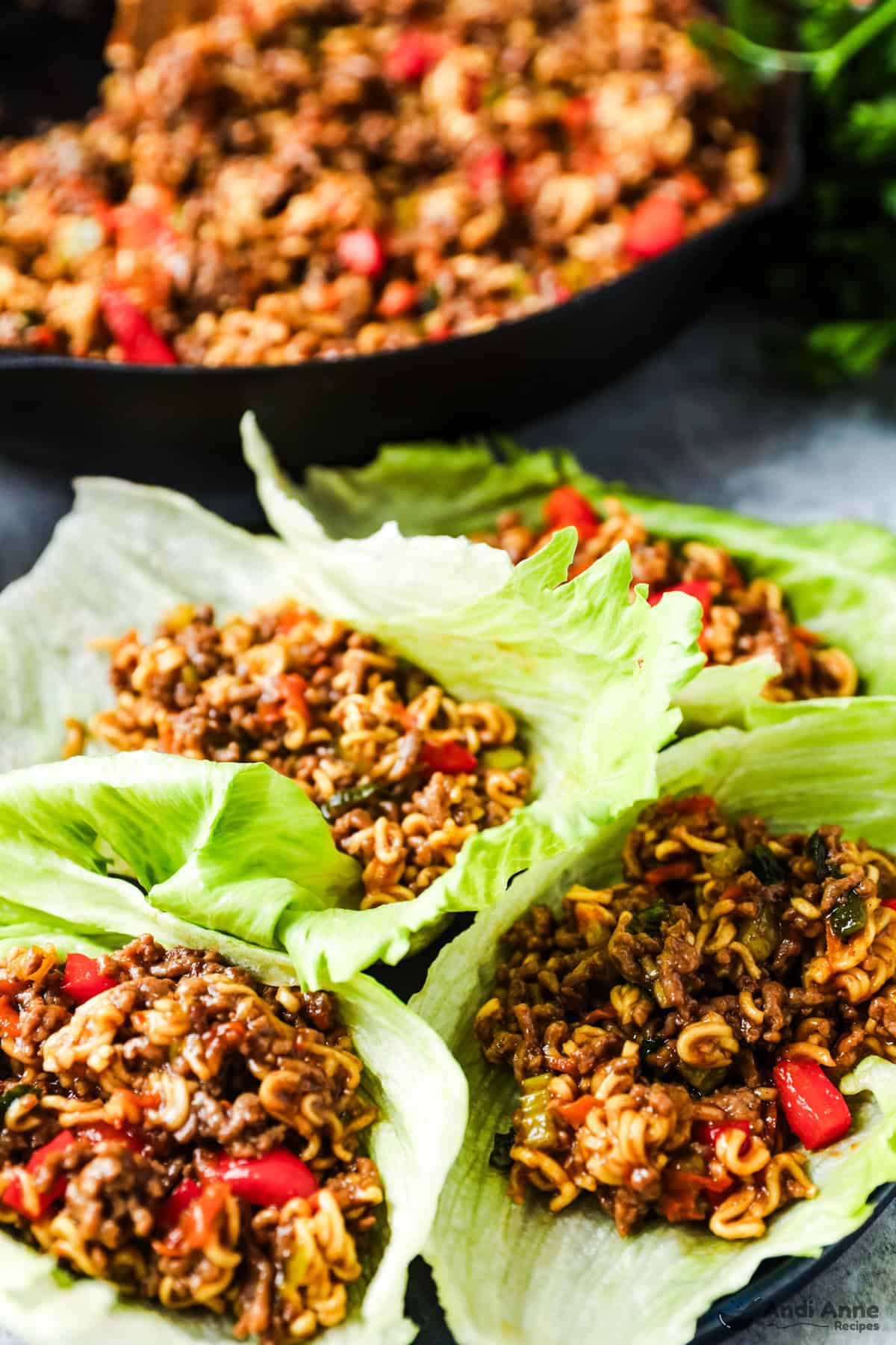 Lettuce leaves with ground beef, ramen noodles, and vegetables in a teriyaki sauce.