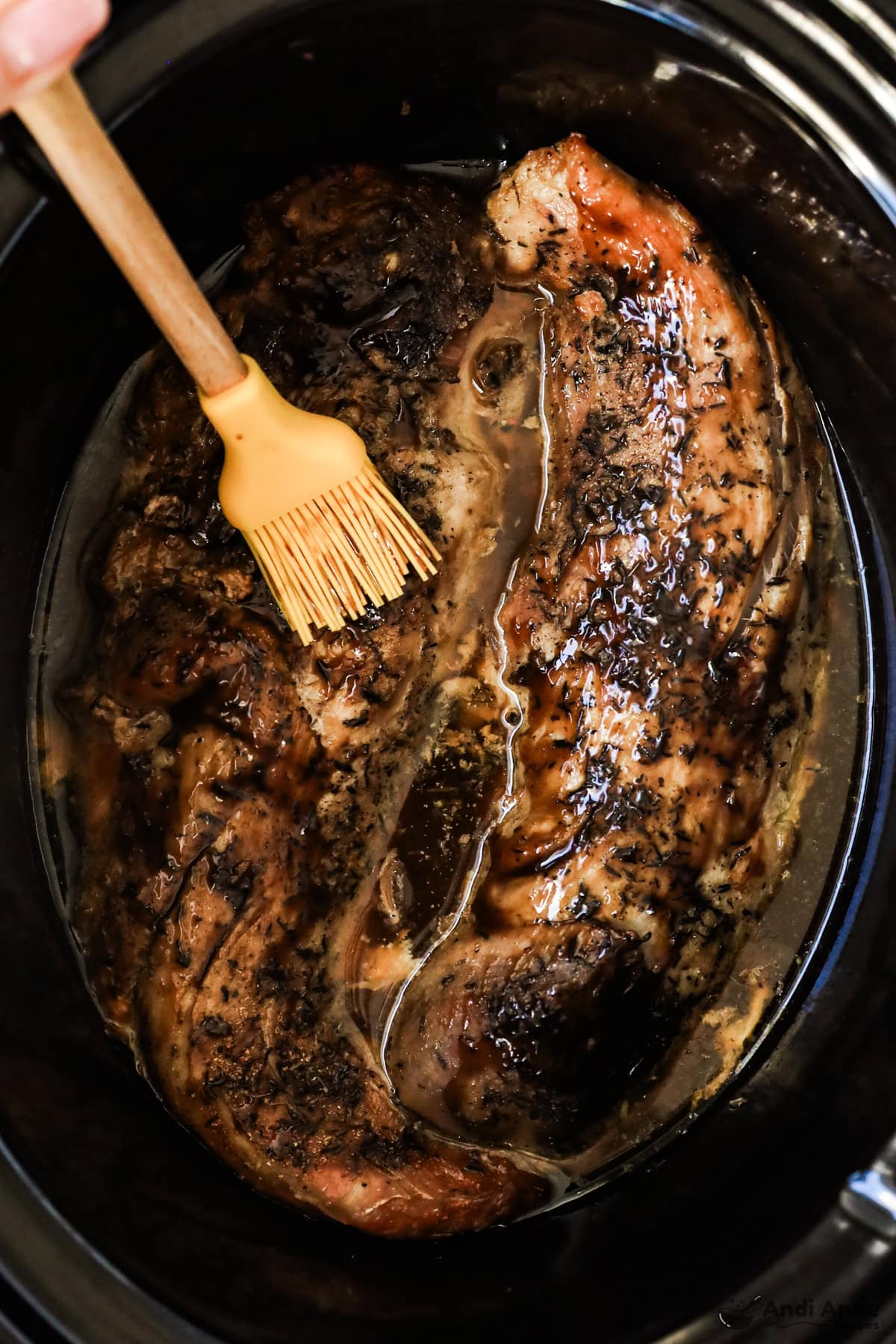 Pork tenderloin in a crockpot spread with sauce