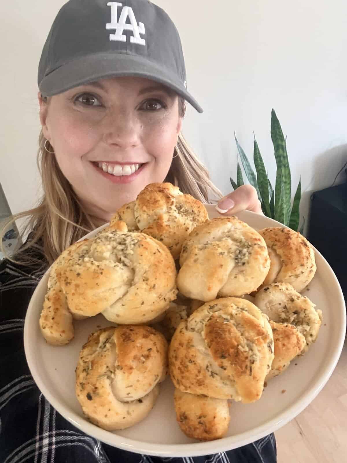 Andi is holding a plate of garlic parmesan knots.