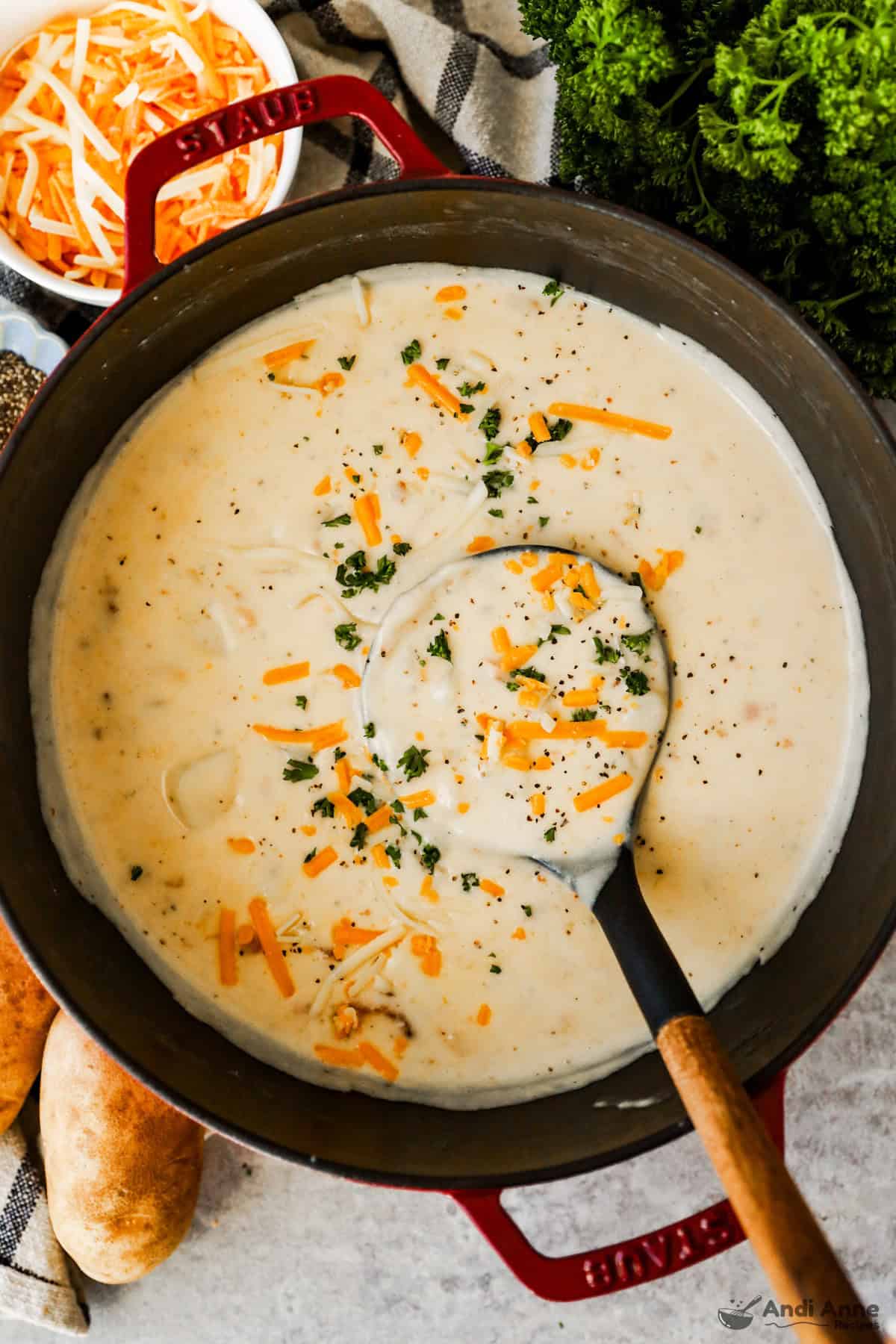 A pot of baked potato soup topped with cheddar cheese.