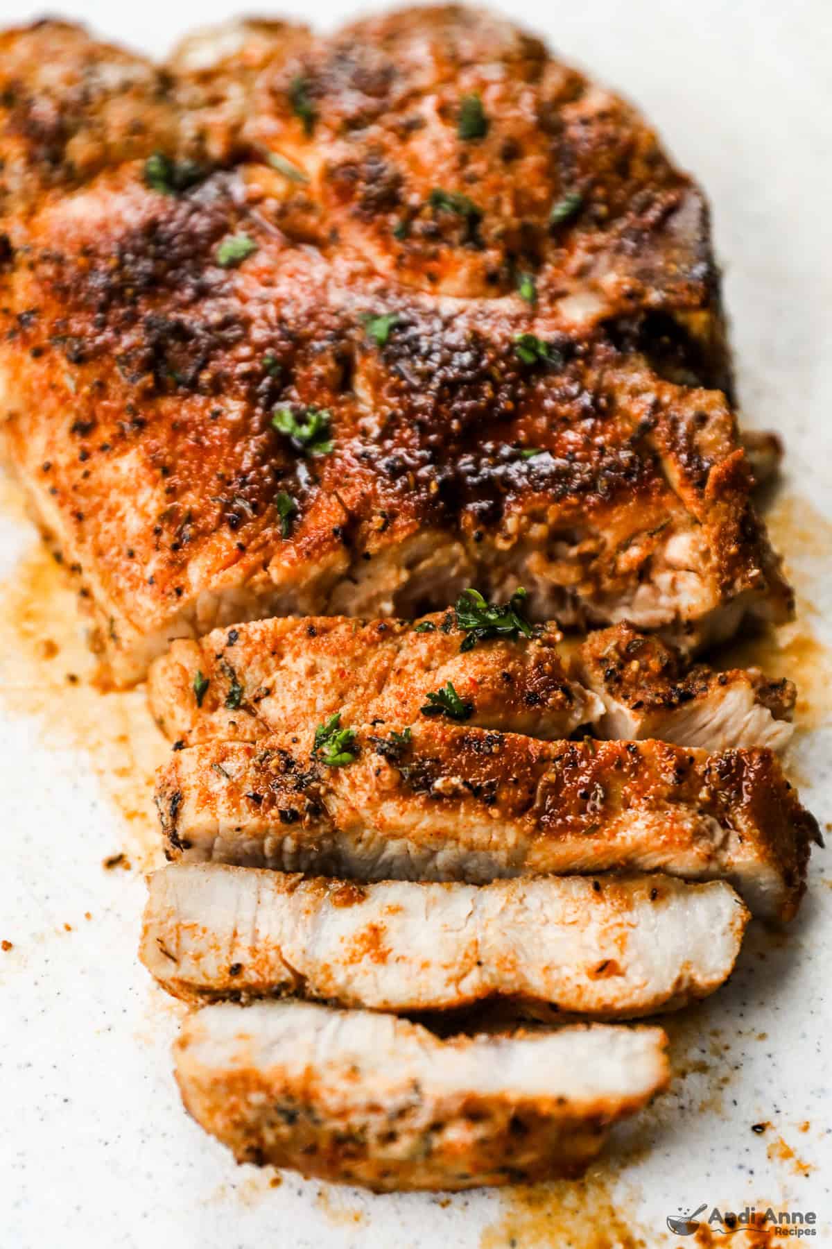 Sliced air fryer pork chops on a cutting board.