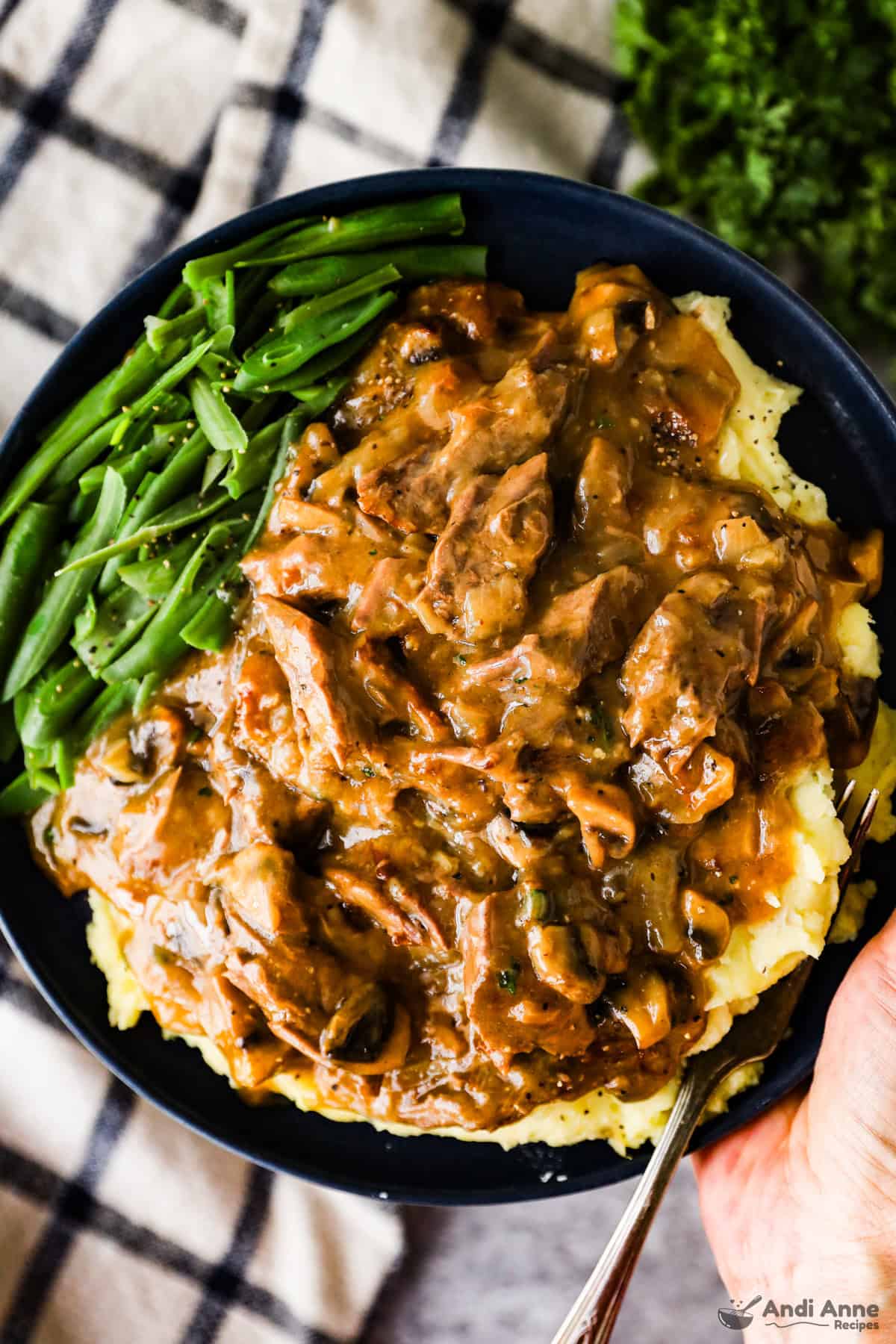 Round steak and gravy over mashed potatoes and a side of gravy.