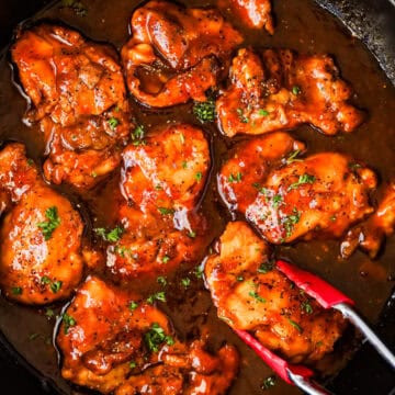 Boneless chicken thighs with sweet and sour sauce in a skillet.