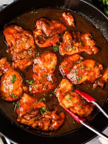 Boneless chicken thighs with sweet and sour sauce in a skillet.