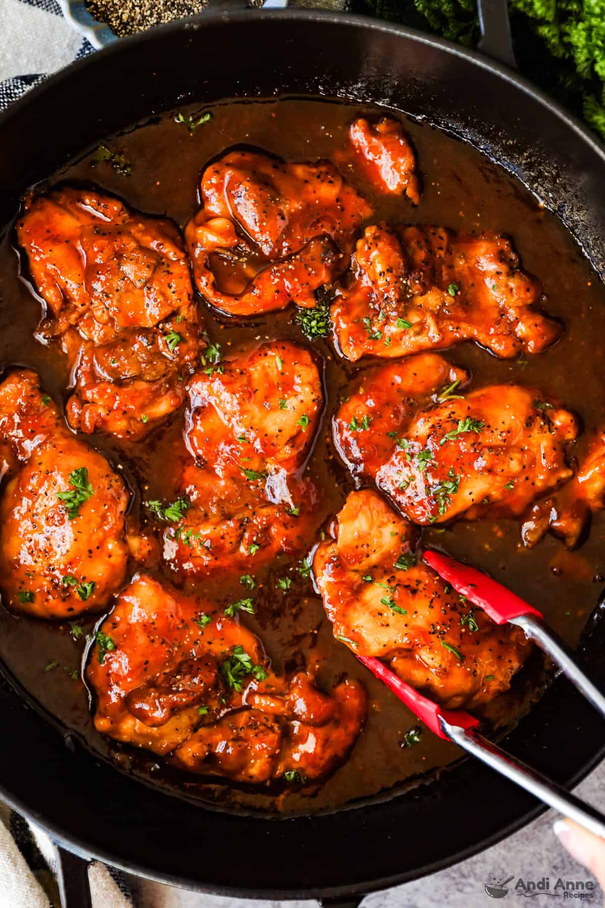 Boneless chicken thighs with sweet and sour sauce in a skillet.