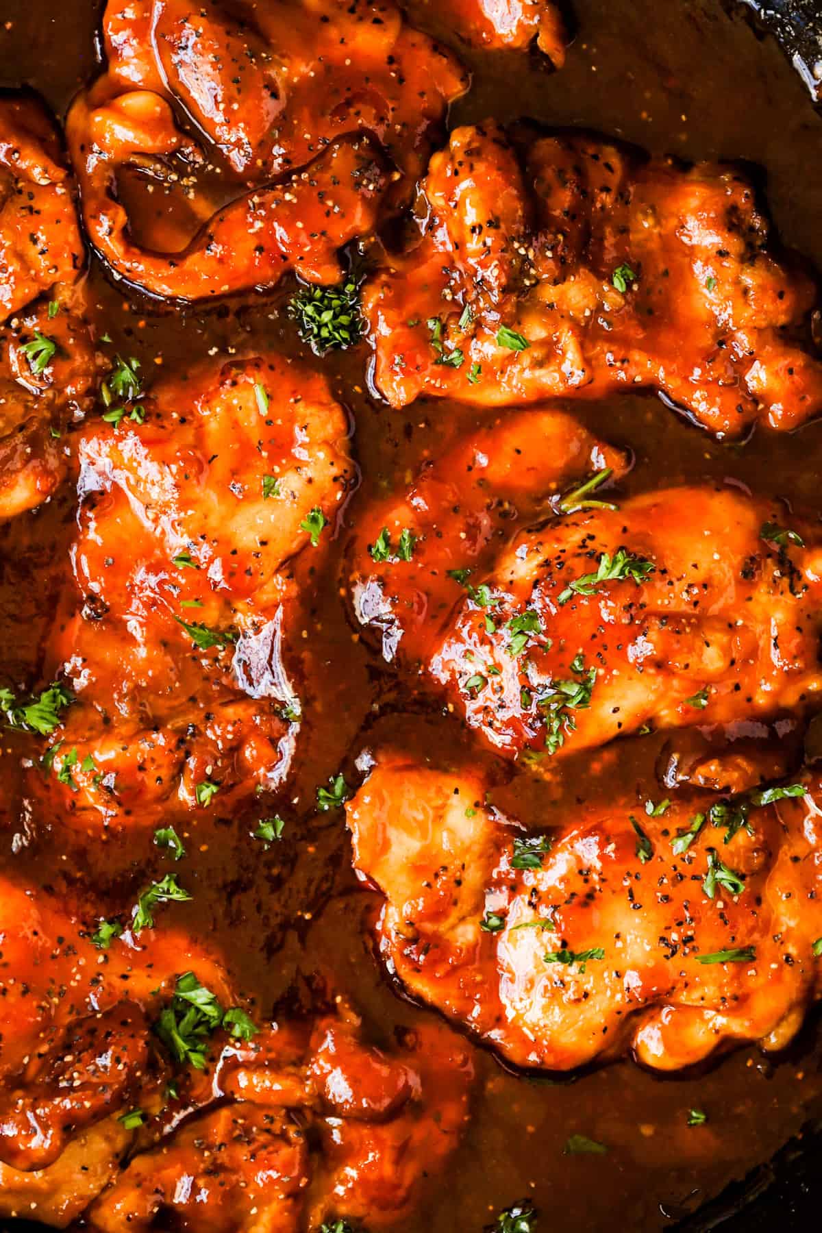 A close-up of boneless chicken thighs in sweet and sour sauce.