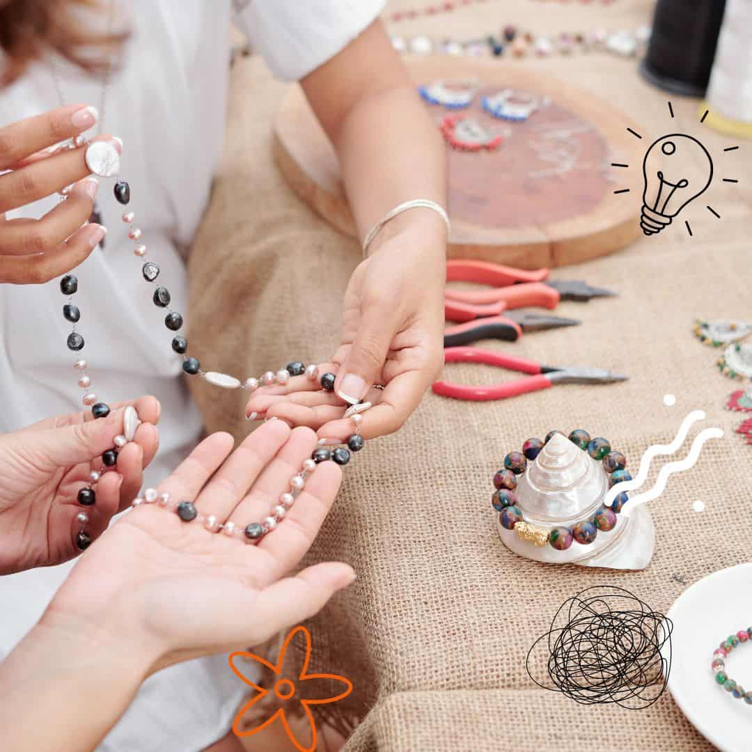 jewelry making with tools and holding a necklace