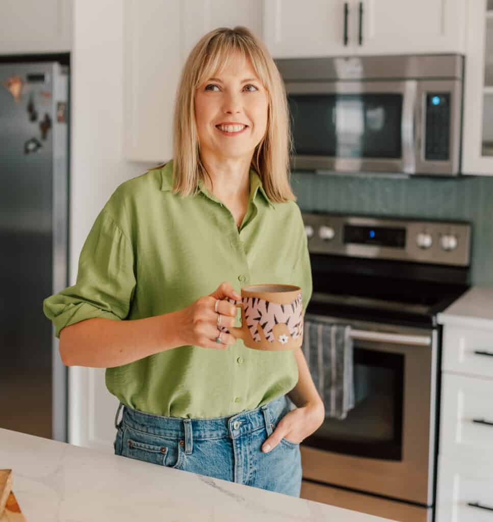 andi holding coffee in kitchen